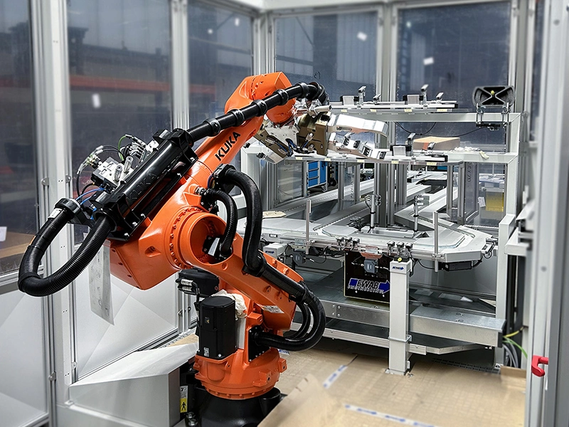 Robot cell loading a pallet conveyor system